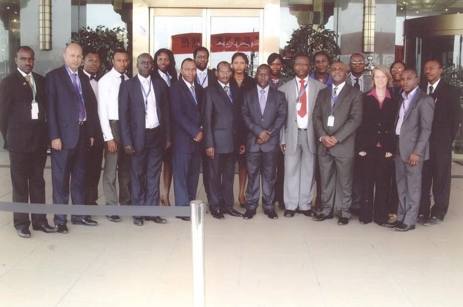 A group of programme delegates in business dress standing outside a hotel entrance